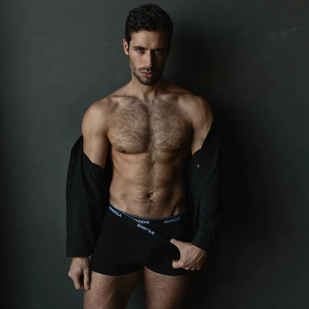 Pose de boudoir masculino contra uma parede de betão
